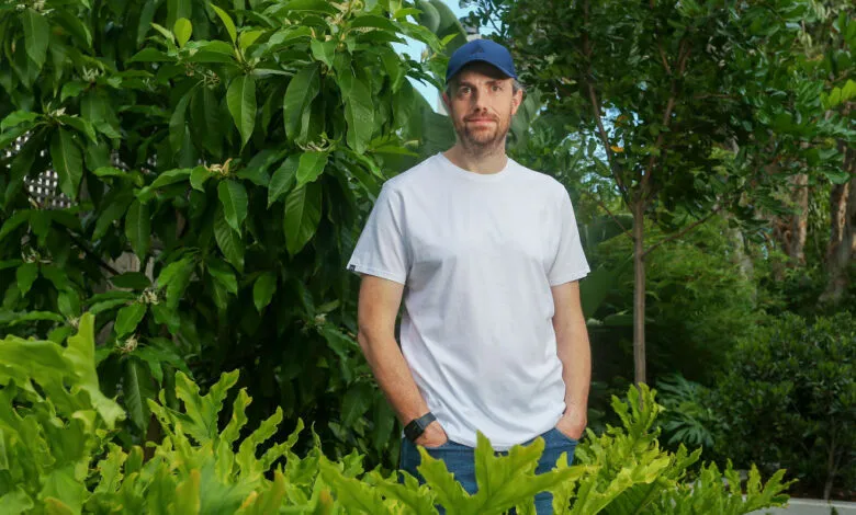 Mike Cannon-Brookes, Atlassian co-founder, stands outdoors in a garden setting.