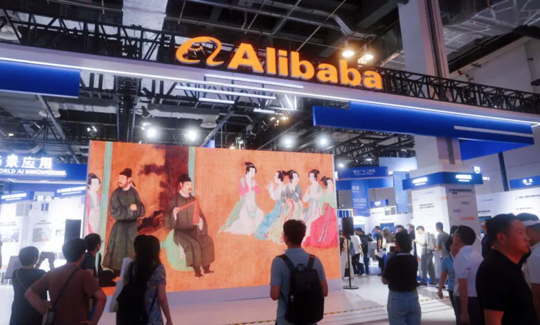 Alibaba's booth at the 2024 WAIC in Shanghai features a large digital display of traditional Chinese art, with attendees gathered around.