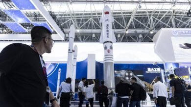 Long March rocket models displayed at the China International Aviation & Aerospace Exhibition in Zhuhai, China. People view the exhibit.
