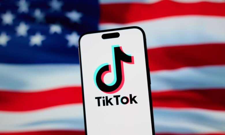 TikTok logo displayed on a smartphone against a blurred US flag background.