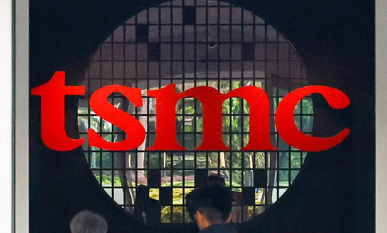 TSMC logo displayed prominently on a dark background, seen through a gridded circular window.