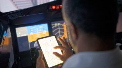 Pilot reviewing flight plan on tablet in cockpit.