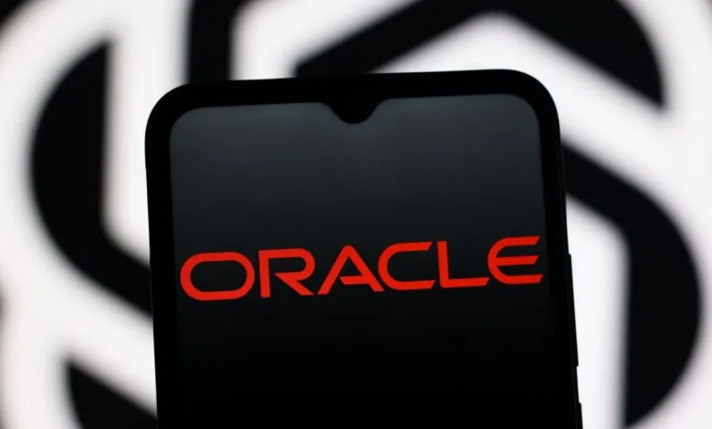 Close-up of a smartphone displaying the Oracle logo in red on a black screen.