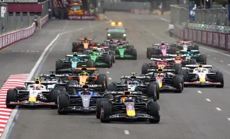 Formula 1 race cars speeding down a track, with a safety car in the background.