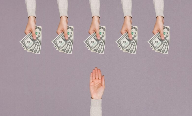 Five hands offer stacks of US dollar bills to a single hand refusing the money.