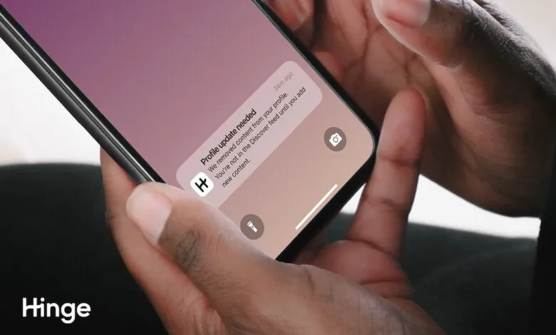 Close-up of hands holding a smartphone displaying a Hinge app notification.