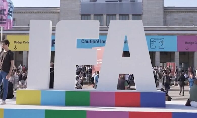 Large IFA letters at a bustling outdoor event, people walking around.