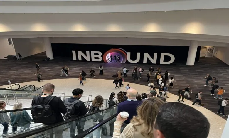Inbound conference attendees gather in a large hall with an Inbound logo display.