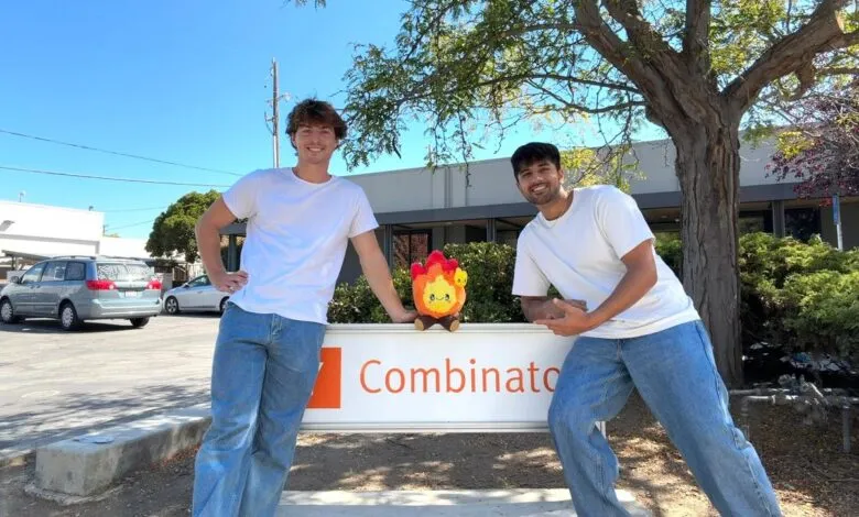 Two men in jeans and white t-shirts pose with a plush toy in front of a Combinato sign.