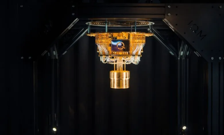 Close-up of IQM Quantum Computer's hardware, showcasing intricate gold-colored circuitry and wiring within a dark, controlled environment.