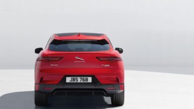 Rear view of a red Jaguar I-Pace electric SUV against a white background.