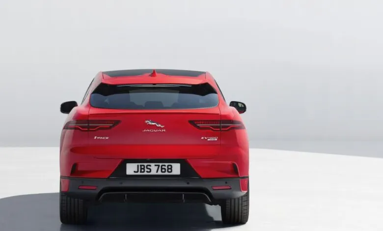 Rear view of a red Jaguar I-Pace electric SUV against a white background.