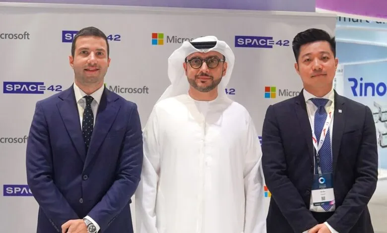 Three men in business attire stand together at a Microsoft and Space42 event in September 2025.