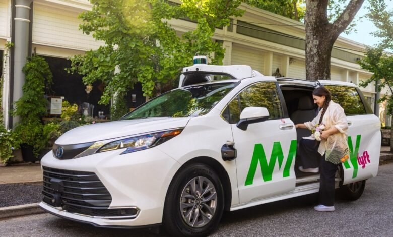 Woman entering a white Lyft self-driving minivan with May Mobility branding in a charming neighborhood setting.
