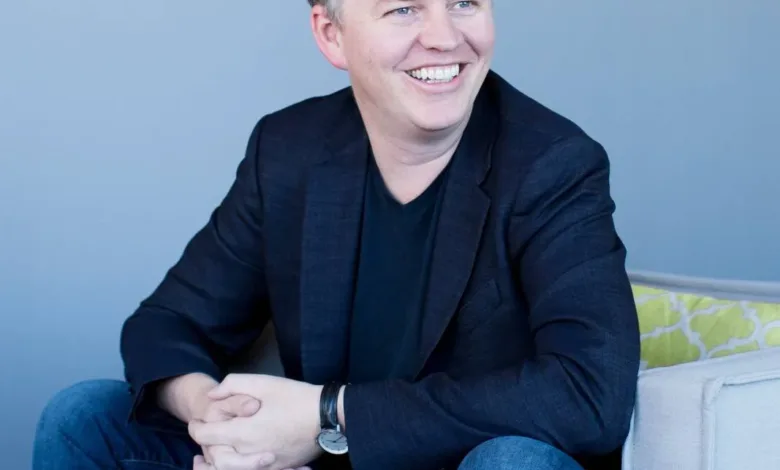 Matthew Prince, CEO of Okta, smiles while sitting in a chair.
