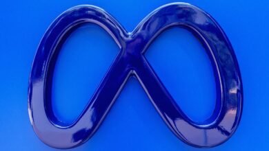 Close-up of a dark blue, infinity-symbol logo against a bright blue background.