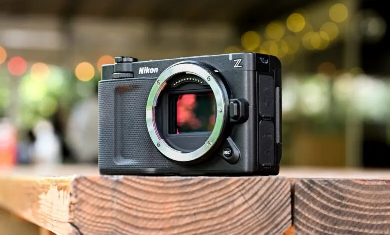 Nikon Z camera on wooden surface, showcasing its sleek design and sensor.