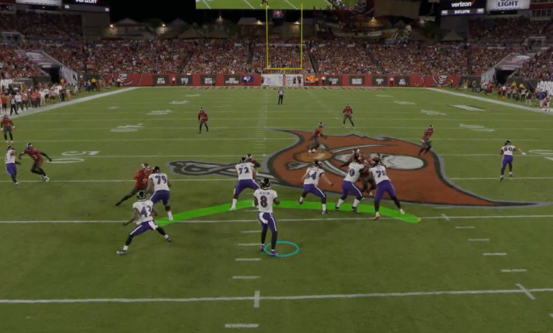 NFL football game, close-up of a play; a player in purple uniform runs with the ball, while Buccaneers players in red try to tackle him.