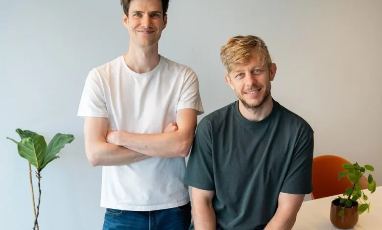 Two smiling men, founders of Polars, stand in an office setting with plants.