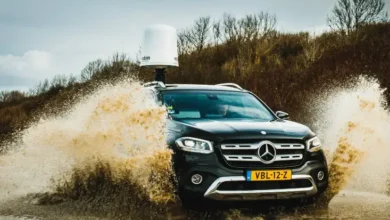 Black Mercedes-Benz X-Class driving through muddy water with a radar system on the roof.