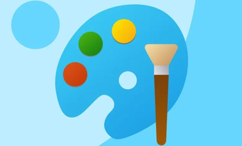 Paintbrush and palette with red, green, and yellow paint.