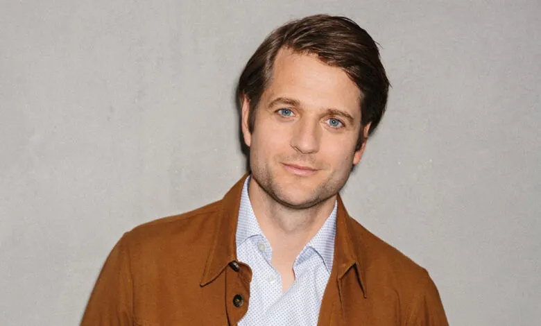 Headshot of Sebastian Siemiatkowski, CEO of Klarna, wearing a brown jacket and light blue shirt.