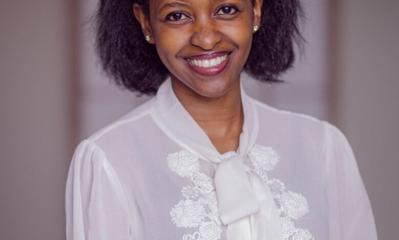 Smiling woman in white blouse with floral detail, professional headshot.
