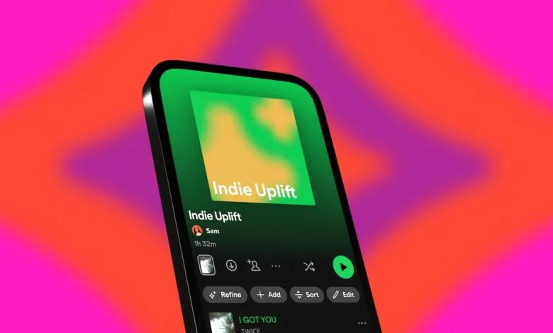 Smartphone displaying a Spotify playlist titled "Indie Uplift" with vibrant colors and play controls.