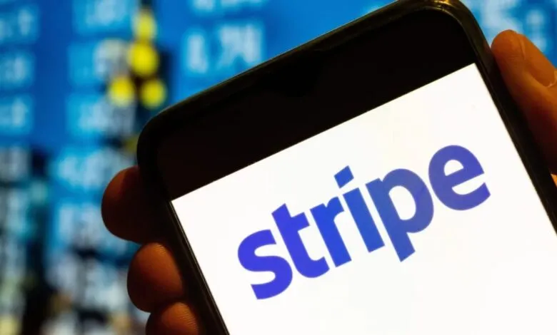 Close-up of a smartphone displaying the Stripe logo against a blurred financial data background.