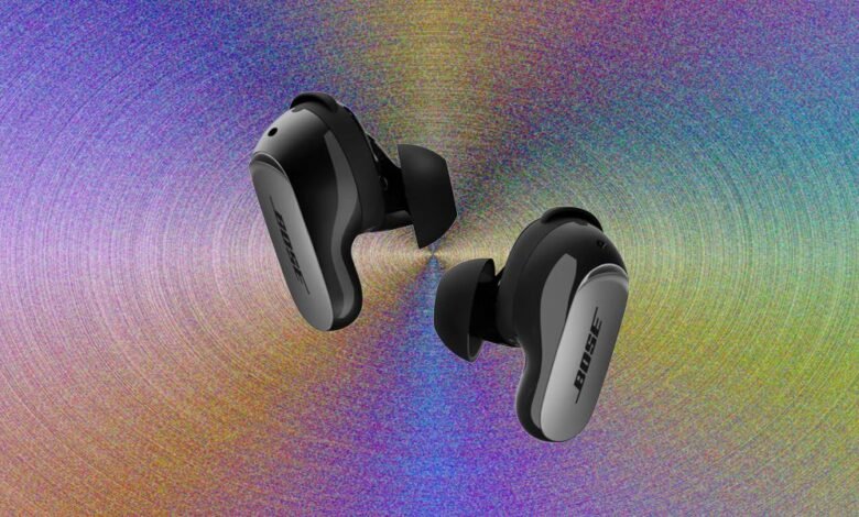 Pair of Bose QuietComfort Ultra earbuds shown against a colorful, textured background.