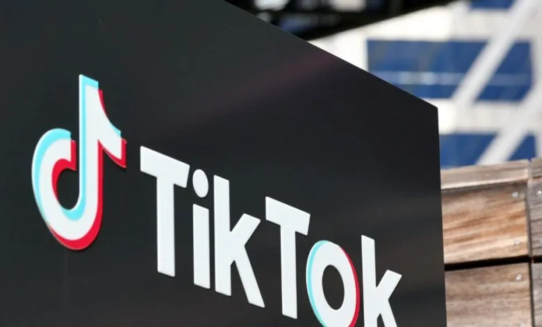 TikTok logo on a black sign, red and blue accents.
