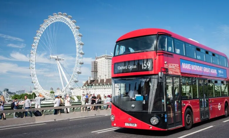 Red London bus on a bridge with the London Eye in the background.