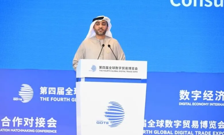 Man in traditional Emirati attire speaking at a podium during the Fourth Global Digital Trade Expo.