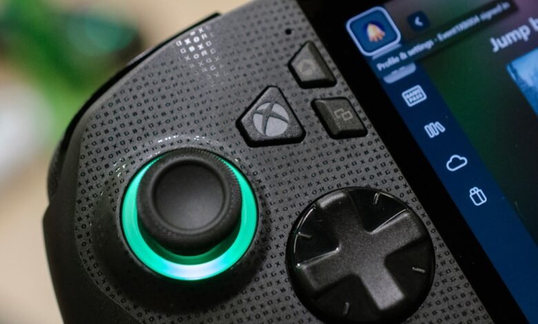 Close-up of a black gaming controller with an illuminated green joystick and Xbox buttons.