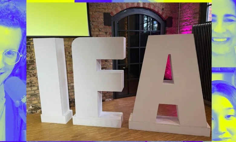 Large white letters spelling IEA stand in a room with brick walls and wooden floors, overlaid with portraits of smiling people.