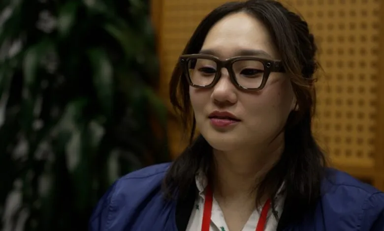 Close-up of a woman wearing Meta Ray-Ban smart glasses, looking thoughtfully.
