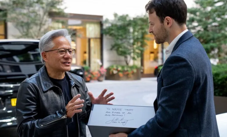 Jensen Huang, Nvidia CEO, receives a gift from a Wayve team member, expressing gratitude for their partnership in autonomous driving.