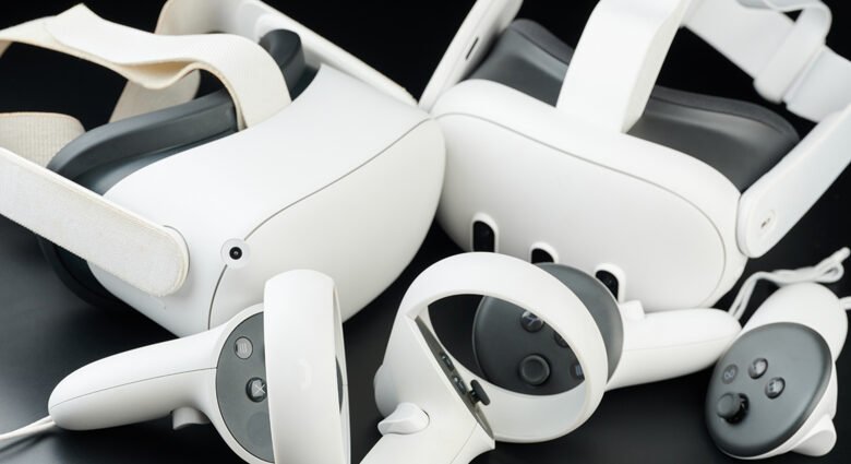 Close-up of Meta Quest VR headsets and controllers. Sleek white design on a dark background.