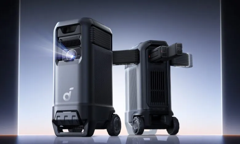 Portable projector with wheels, projecting a bright beam of light. Sleek, dark gray design.