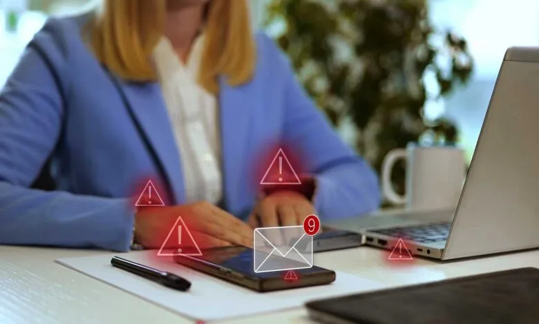 Woman receives suspicious email alert on her phone. Red warning signs surround the message.