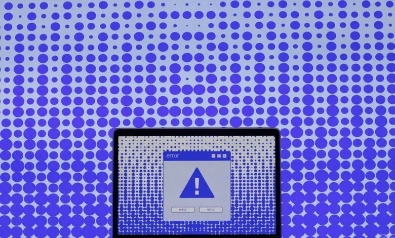Laptop displaying an error message against a background of purple circles.