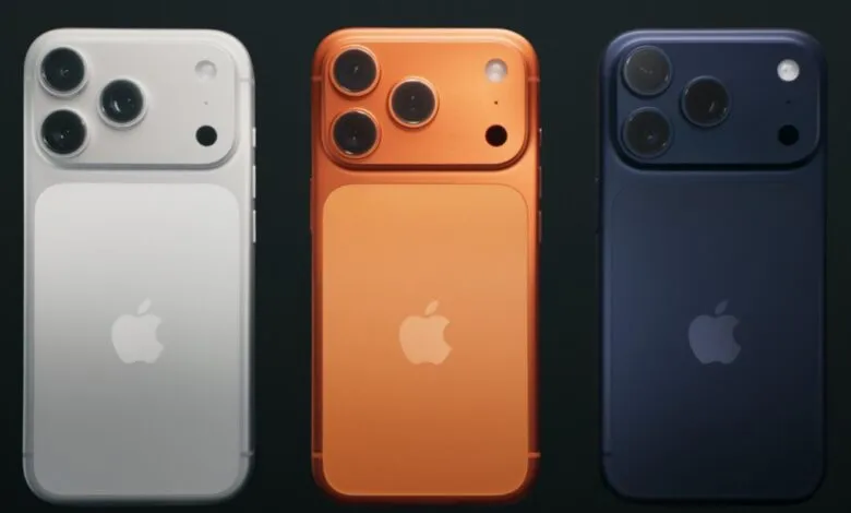 Three new iPhone models in silver, orange, and dark blue, showcasing a redesigned camera system.