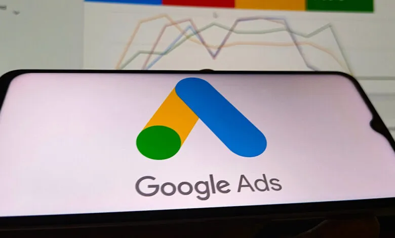 Google Ads logo displayed on a smartphone screen with an analytics dashboard in the background.