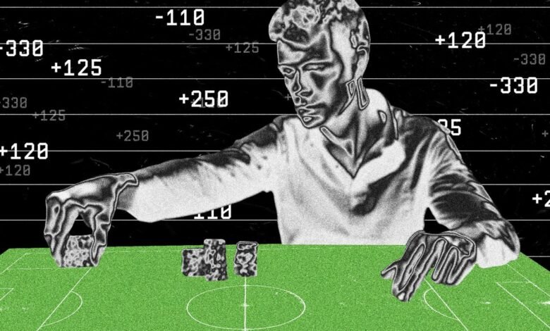 Person analyzes sports betting odds displayed on a screen, manipulating game pieces on a miniature field.