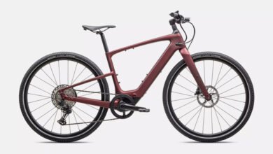 Sleek, maroon electric bike with carbon fiber frame, showcasing its modern design and integrated technology.