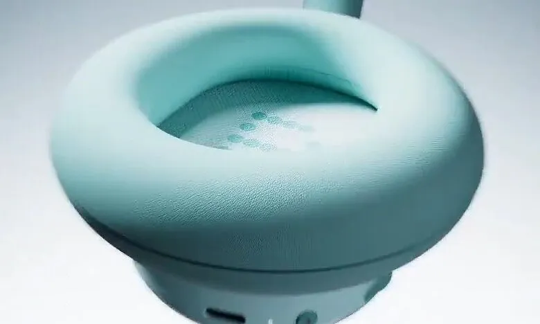 Close-up of a light teal headphone earcup, showcasing its soft texture and subtle speaker grill.