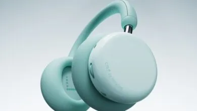 Close-up of a pair of light teal over-ear headphones with the CMF by Nothing logo.