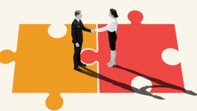 Businesspeople shaking hands on connecting puzzle pieces, symbolizing partnership and collaboration.