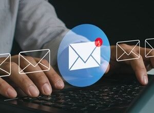 Person checking email on laptop, new message notification shown.