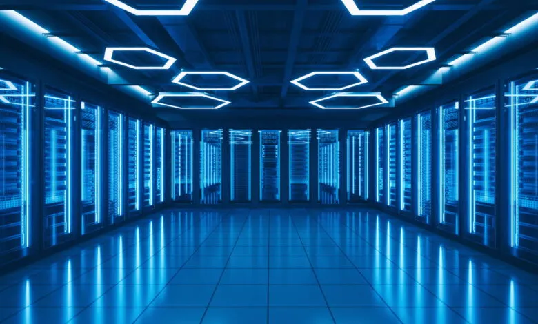 Modern server room with rows of illuminated server racks and a blue-lit hexagonal ceiling.